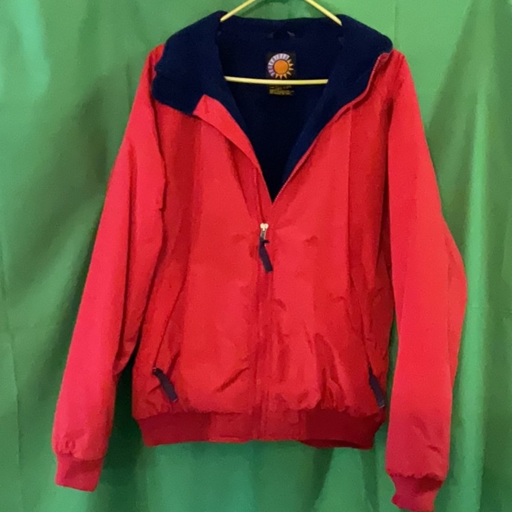Bright red windbreaker with navy blue fleece lining and insulated sleeves.